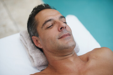 Fototapeta na wymiar Complete calm and relaxation made easy. a handsome mature man enjoying a massage at a spa.