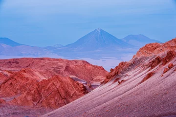 Poster Desert landscape with barren rocks and volcano in the blue hour just after sunset, Moon Valley (Valle de la Luna) Chile © Chris