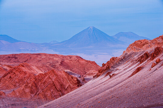 Desert landscape with barren rocks and volcano in the blue hour just after sunset, Moon Valley (Valle de la Luna) Chile
