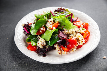 quinoa salad tomato, green lettuce mix healthy meal food snack on the table copy space food background rustic top view keto or paleo diet veggie vegan or vegetarian food