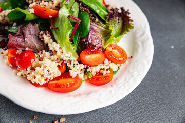 quinoa salad tomato, green lettuce mix healthy meal food snack on the table copy space food background rustic top view keto or paleo diet veggie vegan or vegetarian food