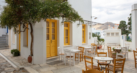 Greece. Tinos island Cyclades. Outdoors traditional cafe with yellow windows at Pyrgos village