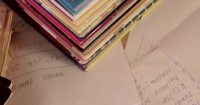 Soft focus camera movement. Handwritten text, exam preparation table element. The books are stacked in a row.
