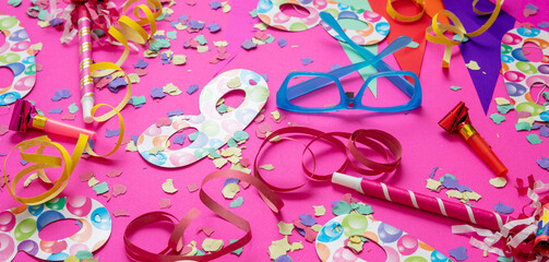 Carnival birthday party. Confetti and serpentines on bright pink background