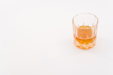 bicchiere in cristallo lavorato con bevanda alcolica isolato su superficie bianca