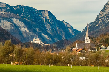Alpine autumn or indian summer view with a church and fortress Hohenwerfen near Werfen, Salzburg, Austria