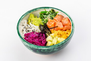 Bowl with salmon, avocado, red cabbage, nachos, cucumber, nori, white and black sesame, chuka. Round green bowl on a white background. Close up 3/4