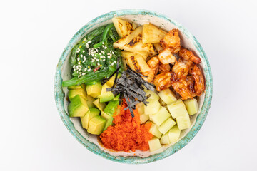 Bowl with fried shrimp, avocado, caviar, pineapple, chuka, cucumber, nori, and sesame seeds. Round green bowl on a white background. Top view