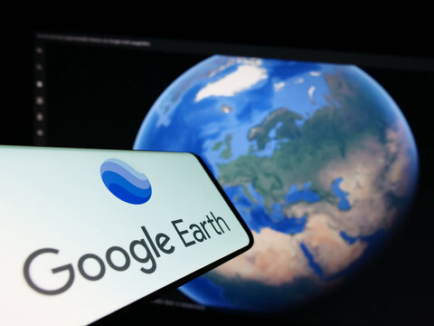 Stuttgart, Germany - 03-10-2023: Mobile phone with logo of satellite imagery software Google Earth on screen in front of website. Focus on right of phone display.