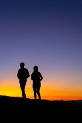 Fototapeta premium Silhouette of a couple in love at sunset background. Hadubai view point Ban Lao Wu, Wiang Haeng, Chiang Mai Copy space for use. Silhouette of lover on hill in sunset