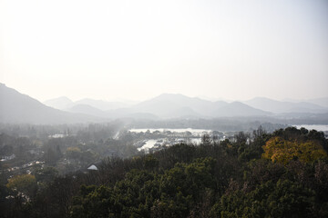 High angle view of the calm seascape and mountains in the cloudy weather. Travel rural scene. West Lake. Popular park of Hangzhou city China.