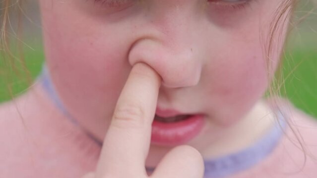 Young Caucasian Girl Picking Nose with Index Finger Front