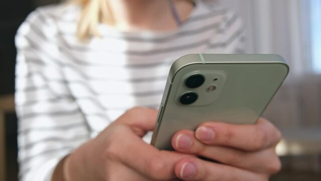 Woman using smartphone pressing finger, reading social media internet, typing text or shopping online. Mobile phone at home or work.