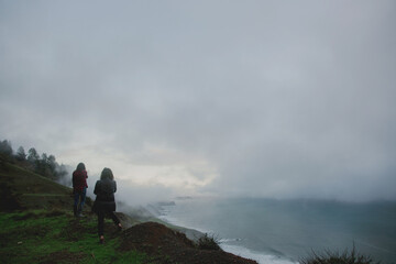 Two girls on a hike looking at the ocean