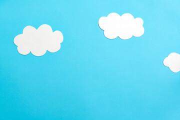 White paper clouds and sky concept on a blue paper, flat lay, top view