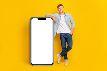 Full size photo of young smart guy hold hand pocket demonstrating new phone collection good software isolated on yellow color background