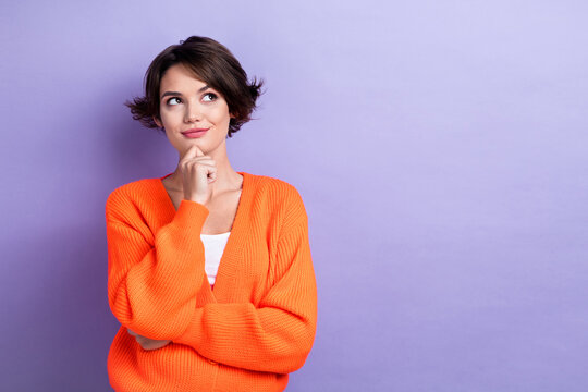 Photo of thoughtful cute lady dressed orange cardigan arm chin looking empty space isolated purple color background