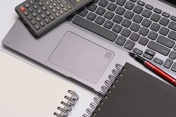 Notes i kalkulator leżące na laptopie na biurku - obrazy, fototapety, plakaty