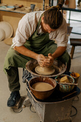 Fototapeta na wymiar Pottery workshop A potter works with clay on a potter's wheel pottery tools