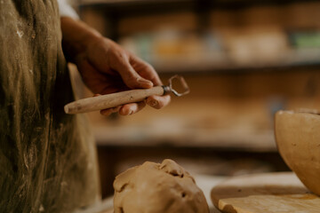 Potter's workshop, a tool for processing clay in the hands of a master clay lies on the table