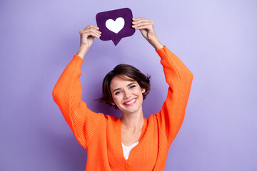 Photo of adorable cheerful lady wear orange trendy clothes arm hold heart card under head isolated...