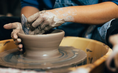 Fototapeta na wymiar Craftsman potter making jug of clay on the potter's wheel circle in workshop
