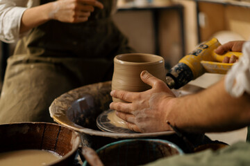 Fototapeta na wymiar In the pottery workshop the potter dries the finished clay jug with a dryer