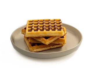 Chocolate waffles on a plate isolated on white background. Waffles in chocolate. Close-up.