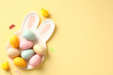 Happy Easter flat lay composition with colorful Easter eggs on plate in shape of cute bunny with ears
