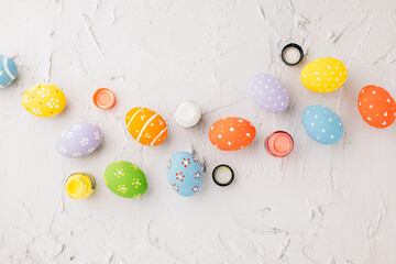 Easter Day Concept. colored multi-colored and paints brush painting easter eggs, colorful paints and paint brushes isolated on white cement background with copy space for text