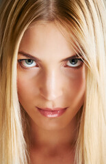 Naklejka premium Blonde beauty. A beautiful young blonde woman looking at the camera with a slight smile.