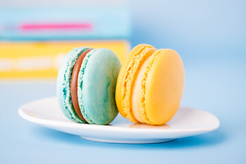 Mint color and yellow sweet macaron on a blue background