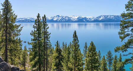 Blue Mountain Lake - A sunny Spring day view of serene blue Lake Tahoe, surrounded by snow-capped...