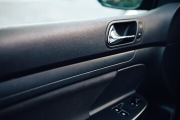 Close up door handle black dark car interior. Dashboard display panel. Climate control. Electric,...