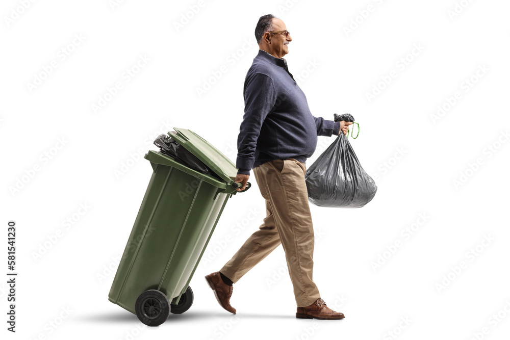 Poster full length profile shot of a mature man walking with a waste bag and pulling a plastic bin