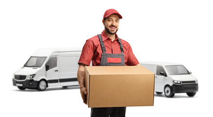 Worker in a uniform holding a cardboard box and standing in front of vans