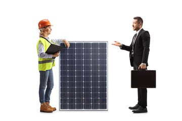 Businessman talking to a female engineer with a solar panel
