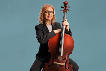 Mature female artist sitting and posing with a cello © Ljupco Smokovski