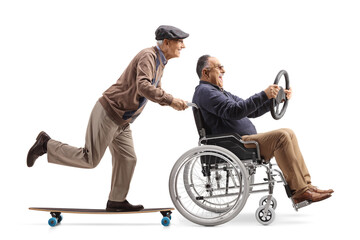 Elderly man with a skateboard pushing a mature man in a wheelchair sitting and holding a steering...