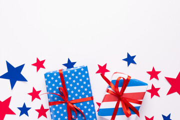 Obraz premium 4th of July American Independence Day. Happy Independence Day. Red, blue and white star confetti, paper decorations on white background. Flat lay, top view, copy space, banner