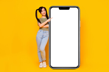 Full body photo of young girl promote recommend new smartphone app website isolated on yellow color...