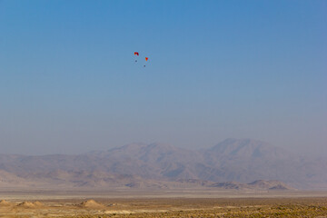 paragliders flying around the pinnacles of Trona Pinnacles, BLM lands in the Mojave Desert of California.