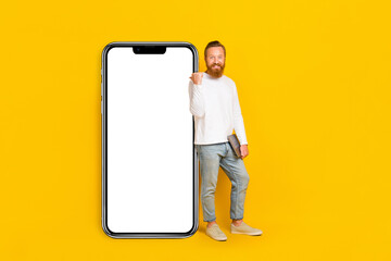 Full body photo of beard man hold laptop index promo wear shirt jeans shoes isolated on yellow color background