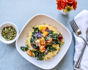 Creamy Polenta with Roasted Butternut Squash and Kale top view with pepitas and flowers