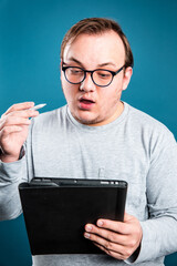 man with glasses holding a tablet
