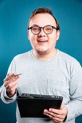 businessman with glasses smiling and holding a tablet