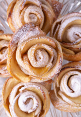 puff buns in the shape of roses with an apple, close-up