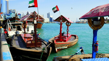 Fototapeta na wymiar bunte Holzfährboote warten am Fluss Creek in Deira (Dubai) am Hafen auf Kunden unter blauem Himmel