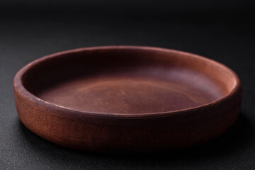 Empty brown colored ceramic plate on dark concrete background