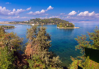 A picturesque green island in the blue bay of Corfu. - obrazy, fototapety, plakaty